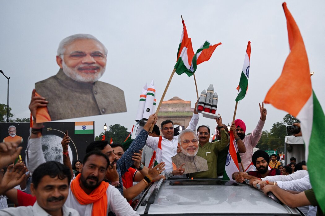 新德里民众挥舞着印度国旗，庆祝“月船3号”在月球南极附近成功着陆